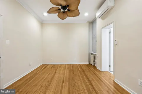 a view of a room with wooden floor and ceiling fan
