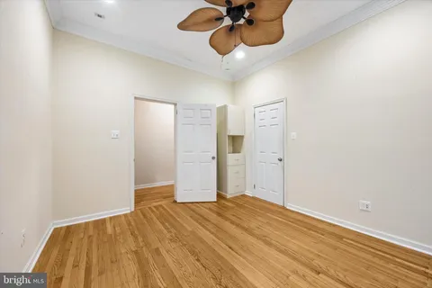 a view of a room with wooden floor and ceiling fan