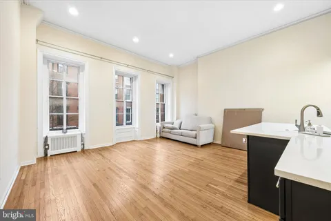 a view of empty room with wooden floor and windows
