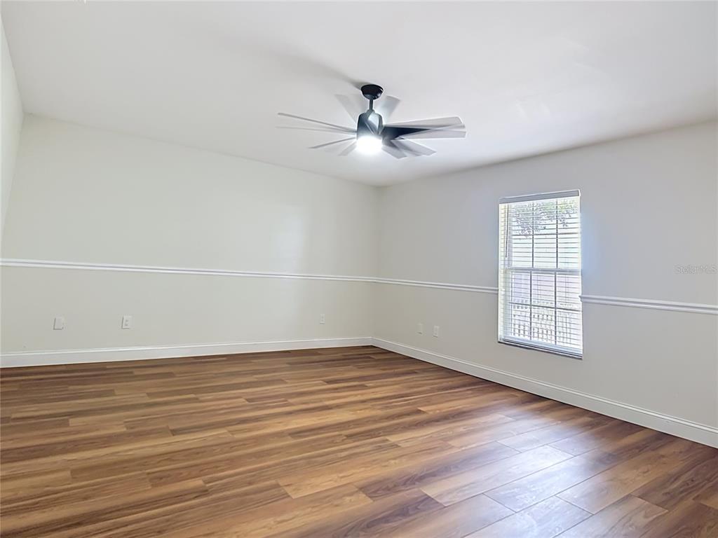 7925 Lake Mabel Loop Road Lake Wales, FL 33898 - Photo 64 of 97 an empty room with wooden floor fan and windows