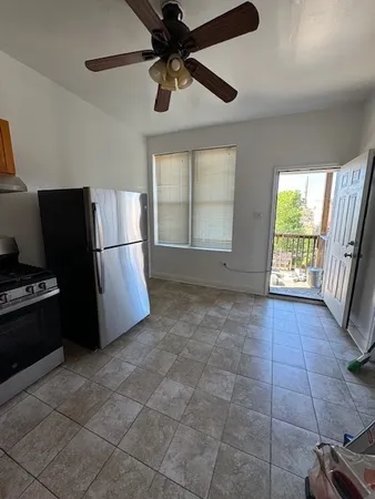 a kitchen with a refrigerator a stove top oven a sink and a window