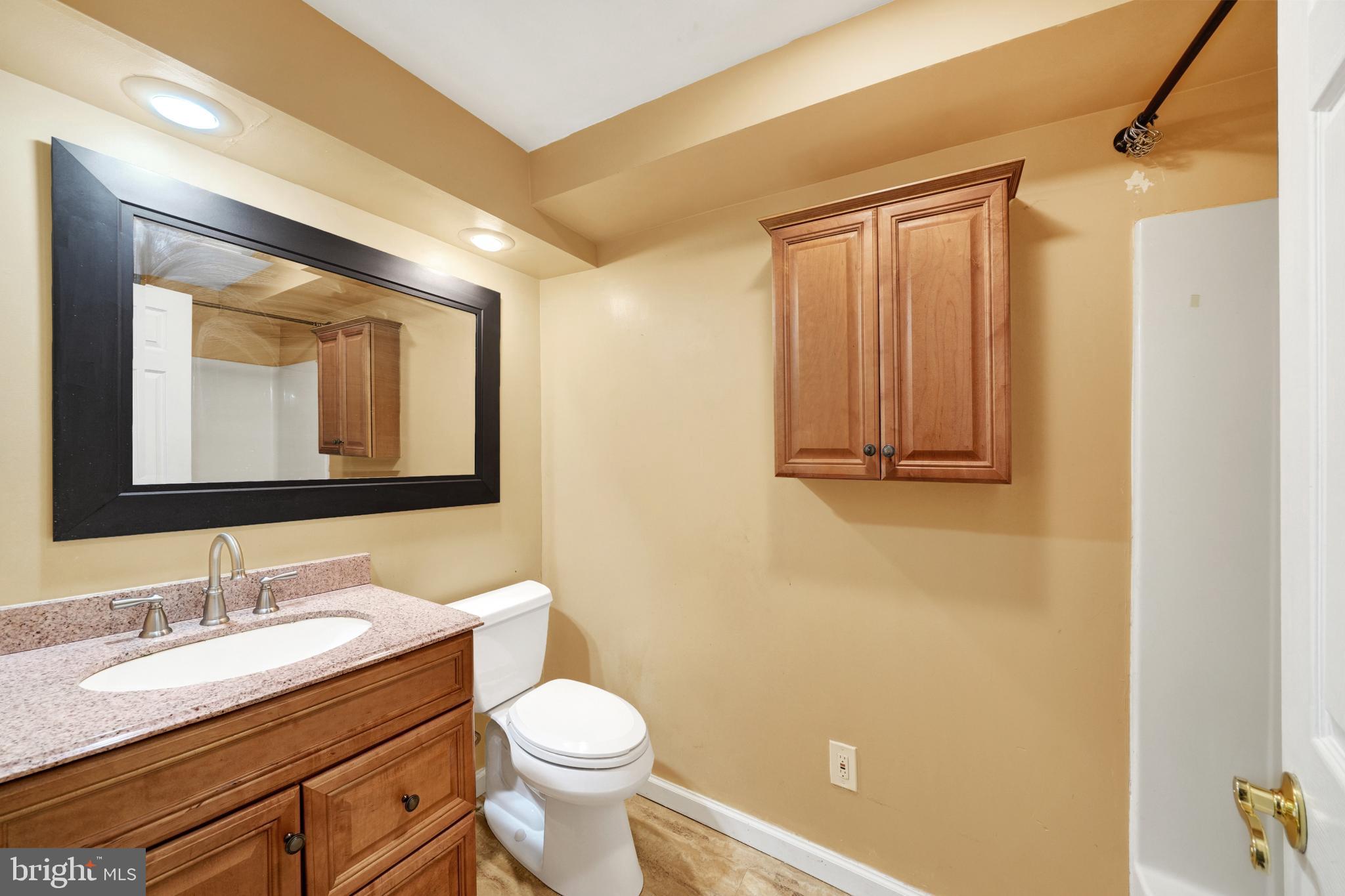 335 East Village Road Elkton, MD 21921 - Photo 12 of 29 a bathroom with a granite countertop sink toilet and mirror