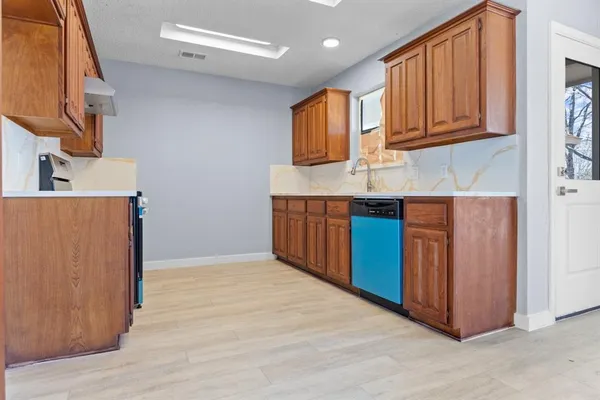 a kitchen with stainless steel appliances granite countertop wooden cabinets a sink and dishwasher