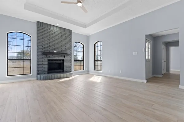 an empty room with windows and fireplace