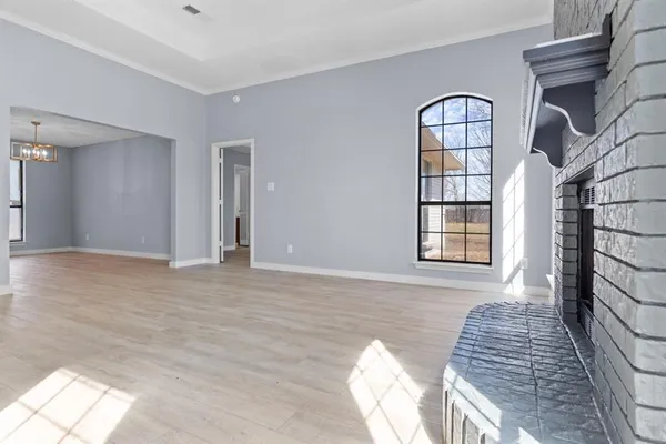 a view of a livingroom with wooden floor and a large window