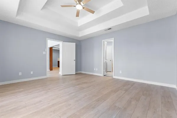 a view of an empty room with a chandelier fan