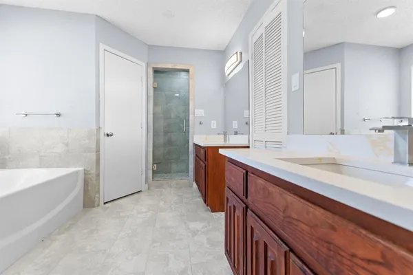 a spacious bathroom with double vanity and a bathtub