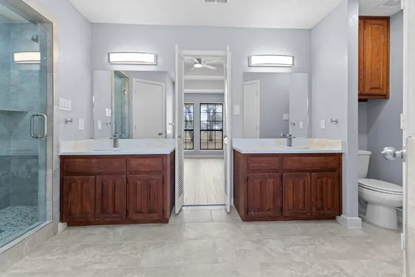 a bathroom with a granite countertop double vanity sink and mirror