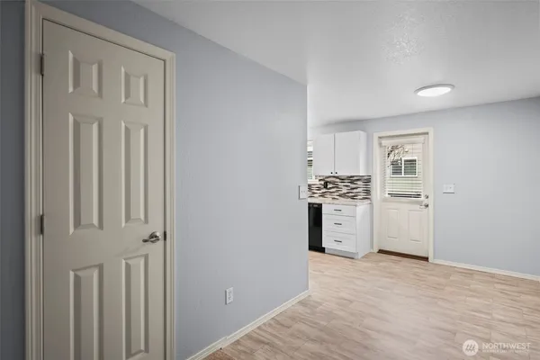 a kitchen with white cabinets and wooden floor