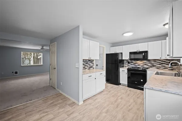 a kitchen with white cabinets and stainless steel appliances