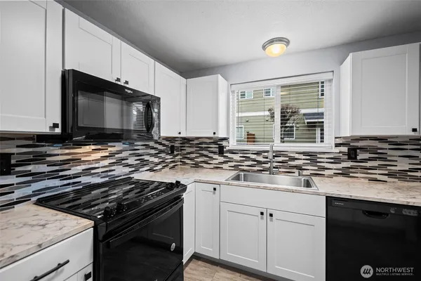 a kitchen with stainless steel appliances a sink dishwasher stove microwave and cabinets