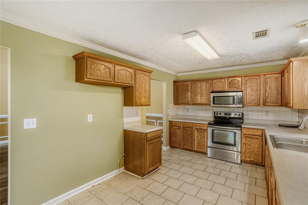 1298 Sierra Ridge Place Southeast Loganville, GA 30052 - Photo 12 of 29 a kitchen with a stove top oven and cabinets