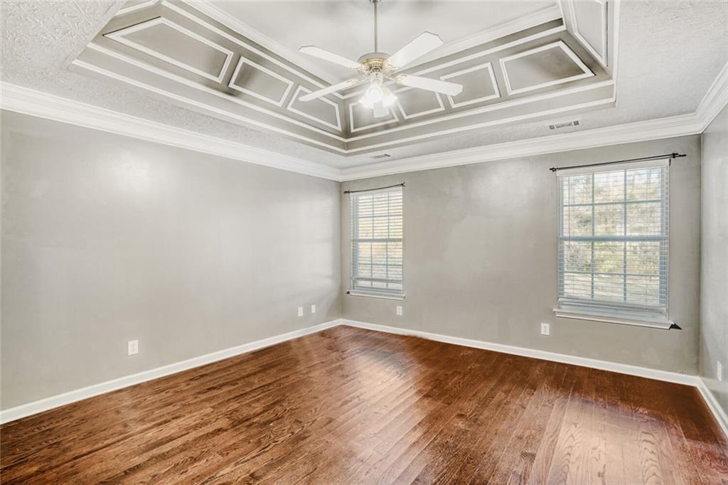 1298 Sierra Ridge Place Southeast Loganville, GA 30052 - Photo 16 of 29 an empty room with wooden floor chandelier and windows