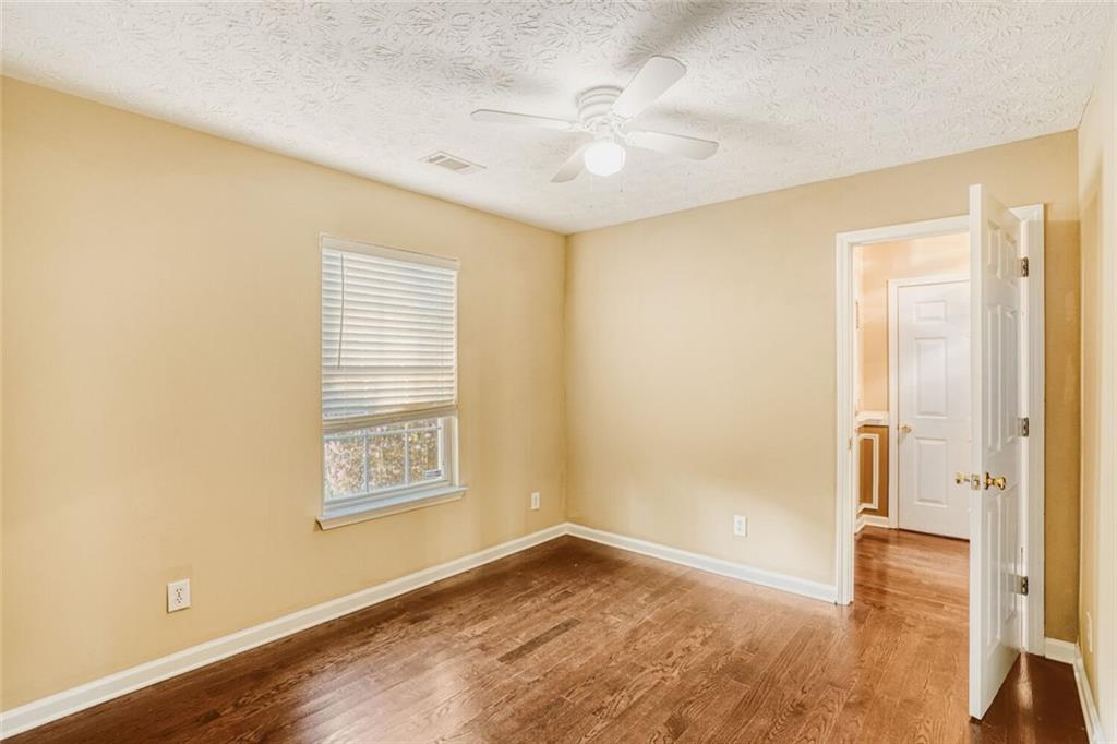 1298 Sierra Ridge Place Southeast Loganville, GA 30052 - Photo 20 of 29 a view of an empty room with wooden floor and a window