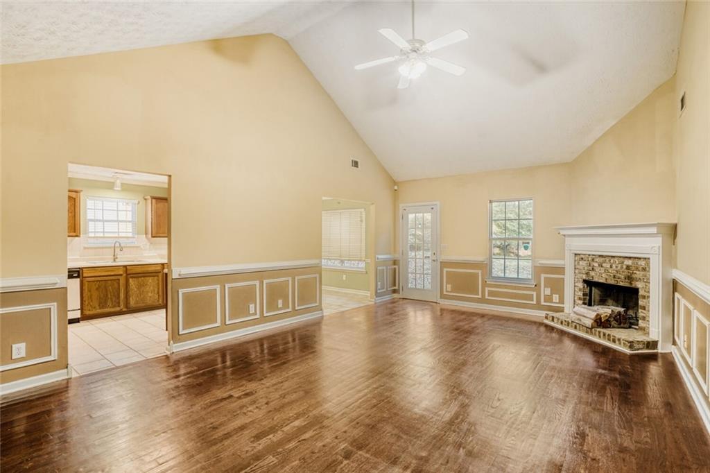 1298 Sierra Ridge Place Southeast Loganville, GA 30052 - Photo 7 of 29 a big room with wooden floor fireplace and windows