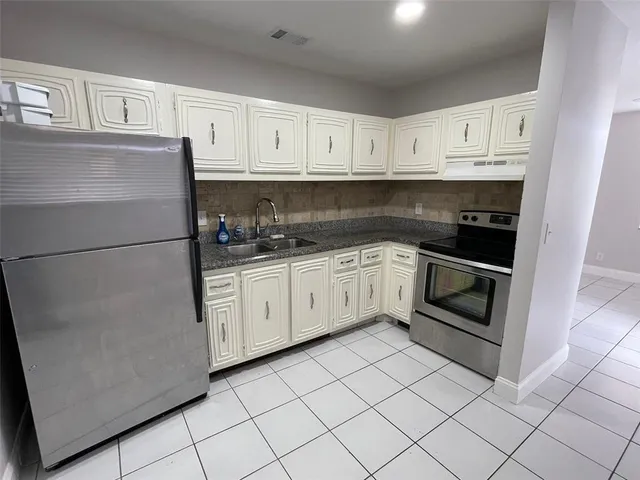 a kitchen with white cabinets and white appliances