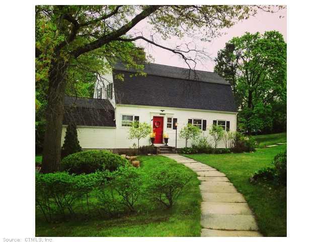 a front view of a house with a yard and trees