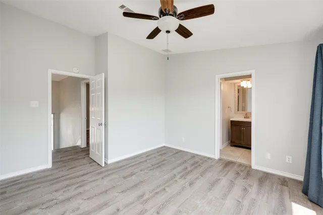 an empty room with wooden floor a ceiling fan and closet