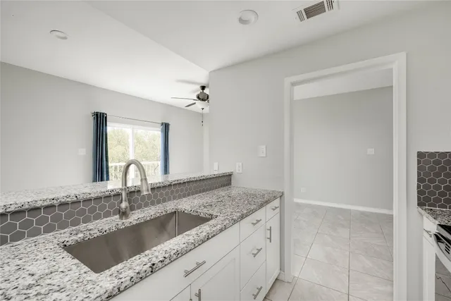 a kitchen with granite countertop a stove and a microwave