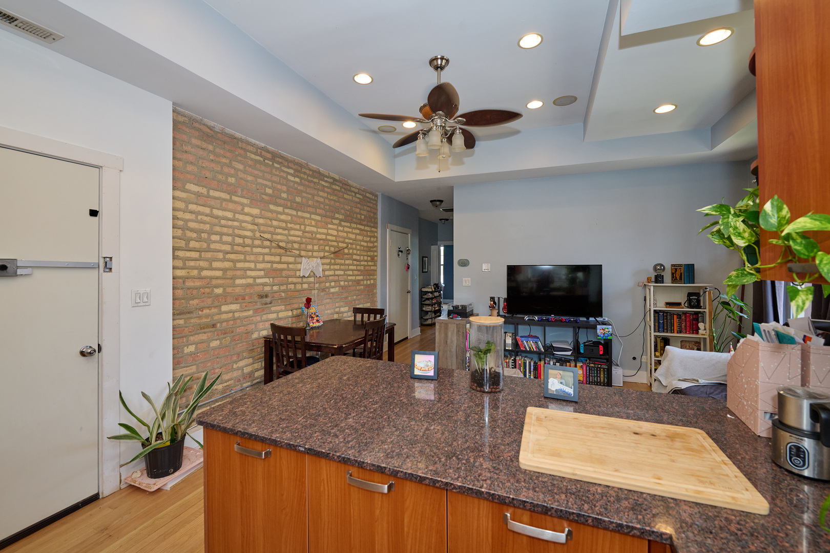 5711 North Kimball Avenue, Unit 3N Chicago, IL 60659 - Photo 7 of 24 a kitchen with a table chairs and a flat screen tv
