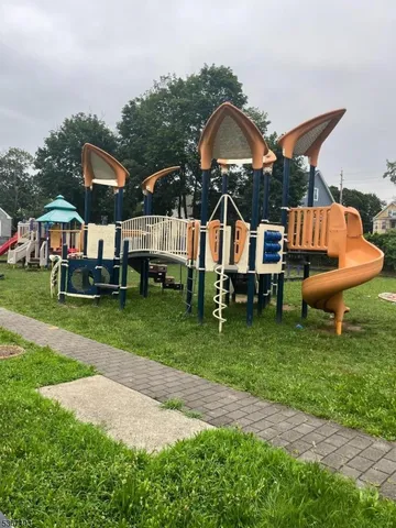 a front view of a house with a garden and slide