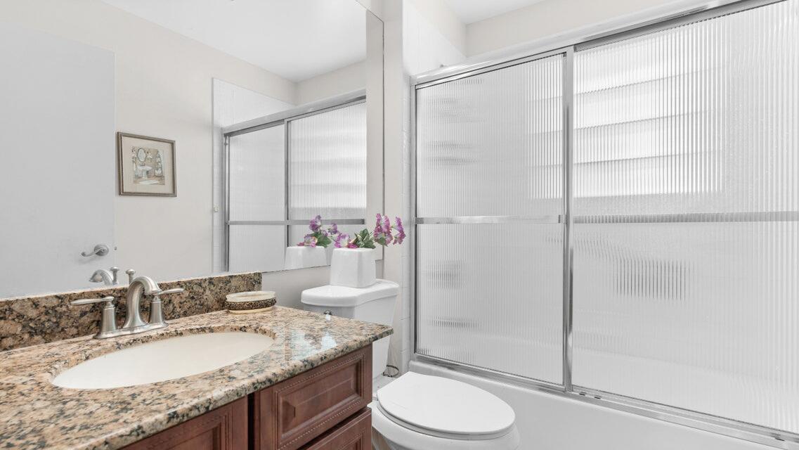 7961 Mansfield Hollow Road Delray Beach, FL 33446 - Photo 11 of 19 a bathroom with a granite countertop sink toilet and shower