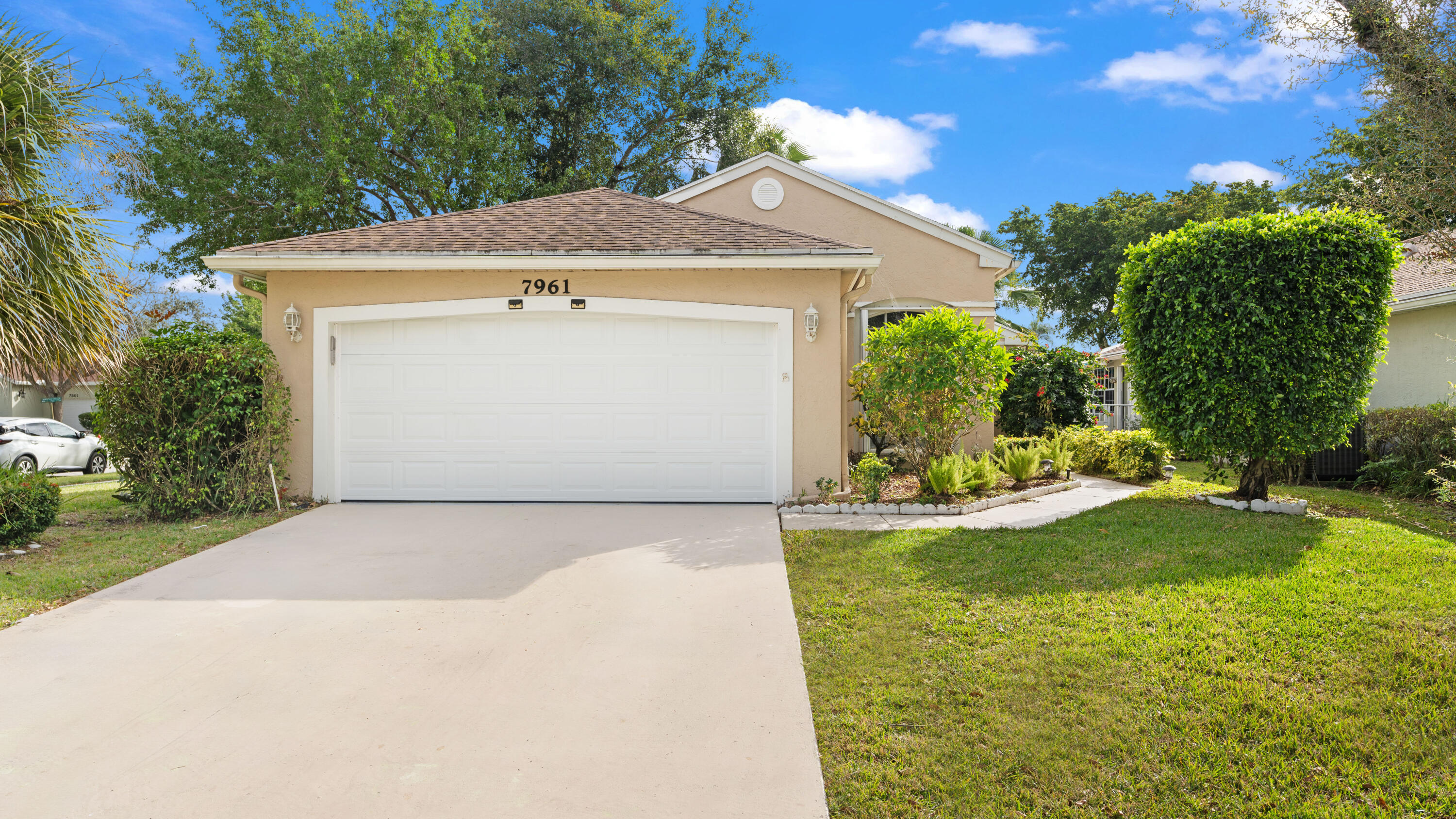 7961 Mansfield Hollow Road Delray Beach, FL 33446 - Photo 4 of 19 a front view of a house with a yard
