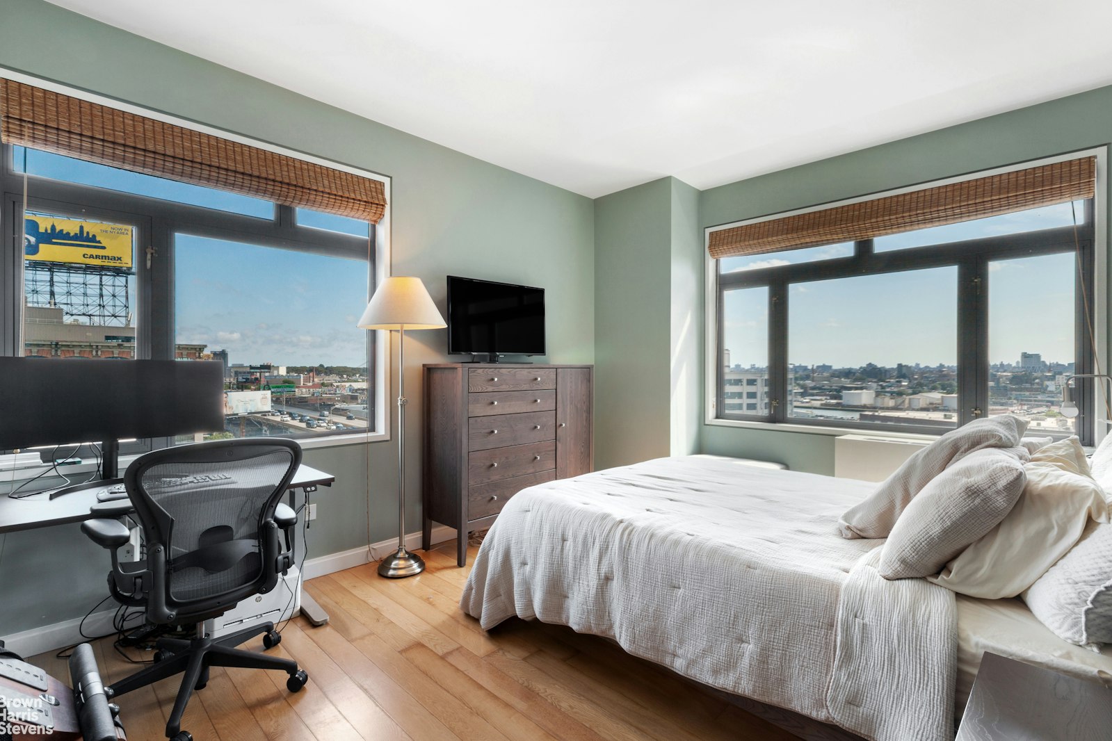 11-02 49th Avenue, Unit 8A Queens, NY 11101 - Photo 23 of 36 a bedroom with a bed and a flat tv screen next to a window