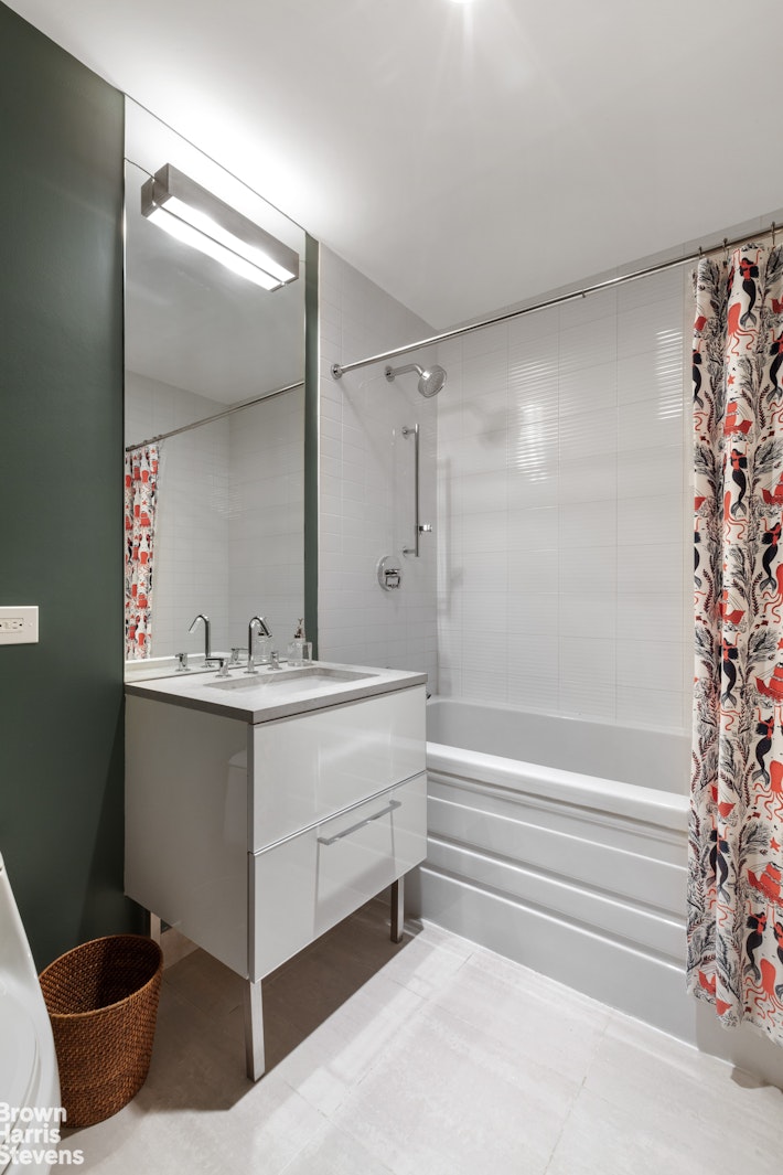 11-02 49th Avenue, Unit 8A Queens, NY 11101 - Photo 26 of 36 a bathroom with a sink and a mirror