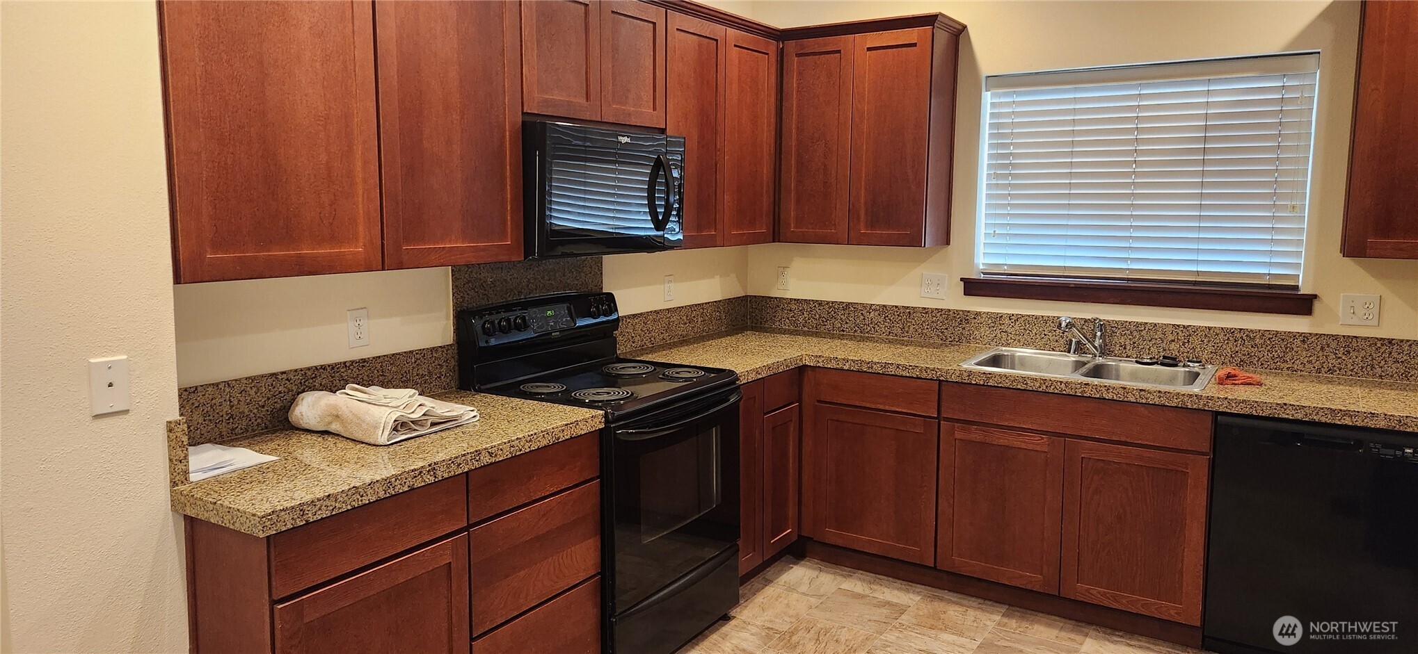 501 North 105th Street, Unit A Seattle, WA 98133 - Photo 2 of 39 a kitchen with granite countertop a sink stove and cabinets