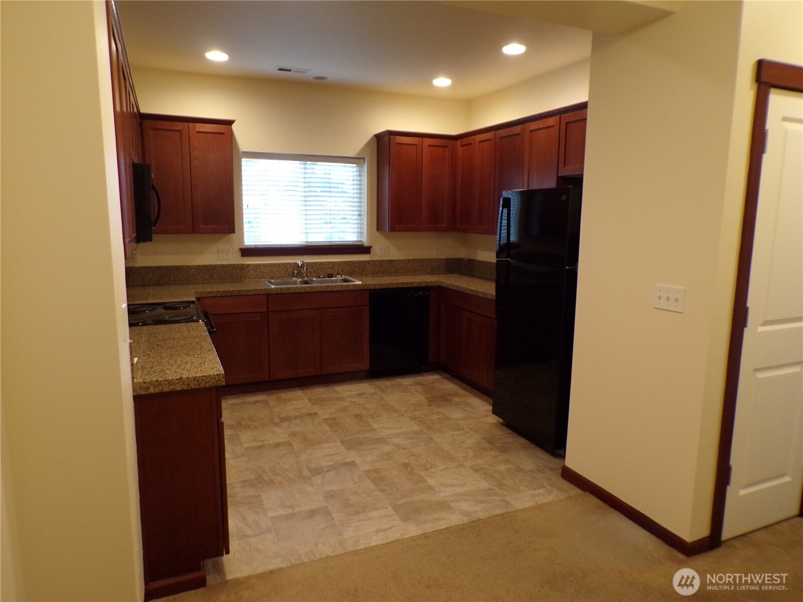 501 North 105th Street, Unit A Seattle, WA 98133 - Photo 6 of 39 a kitchen with granite countertop a refrigerator and a stove top oven