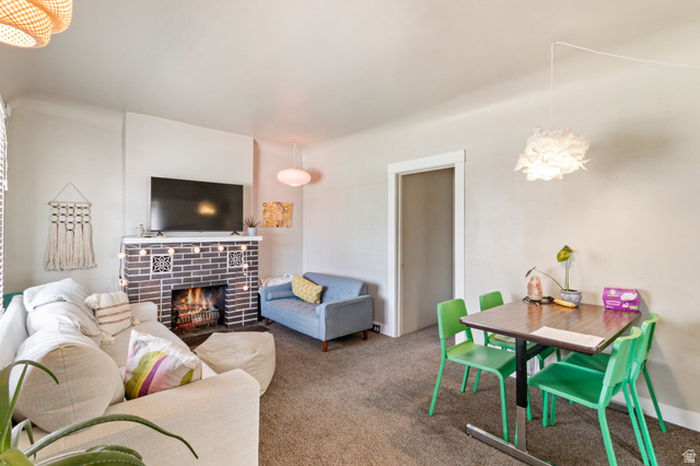 386 North 500 East Provo, UT 84606 - Photo 2 of 24 Living room featuring a fireplace, carpet floors, and a chandelier