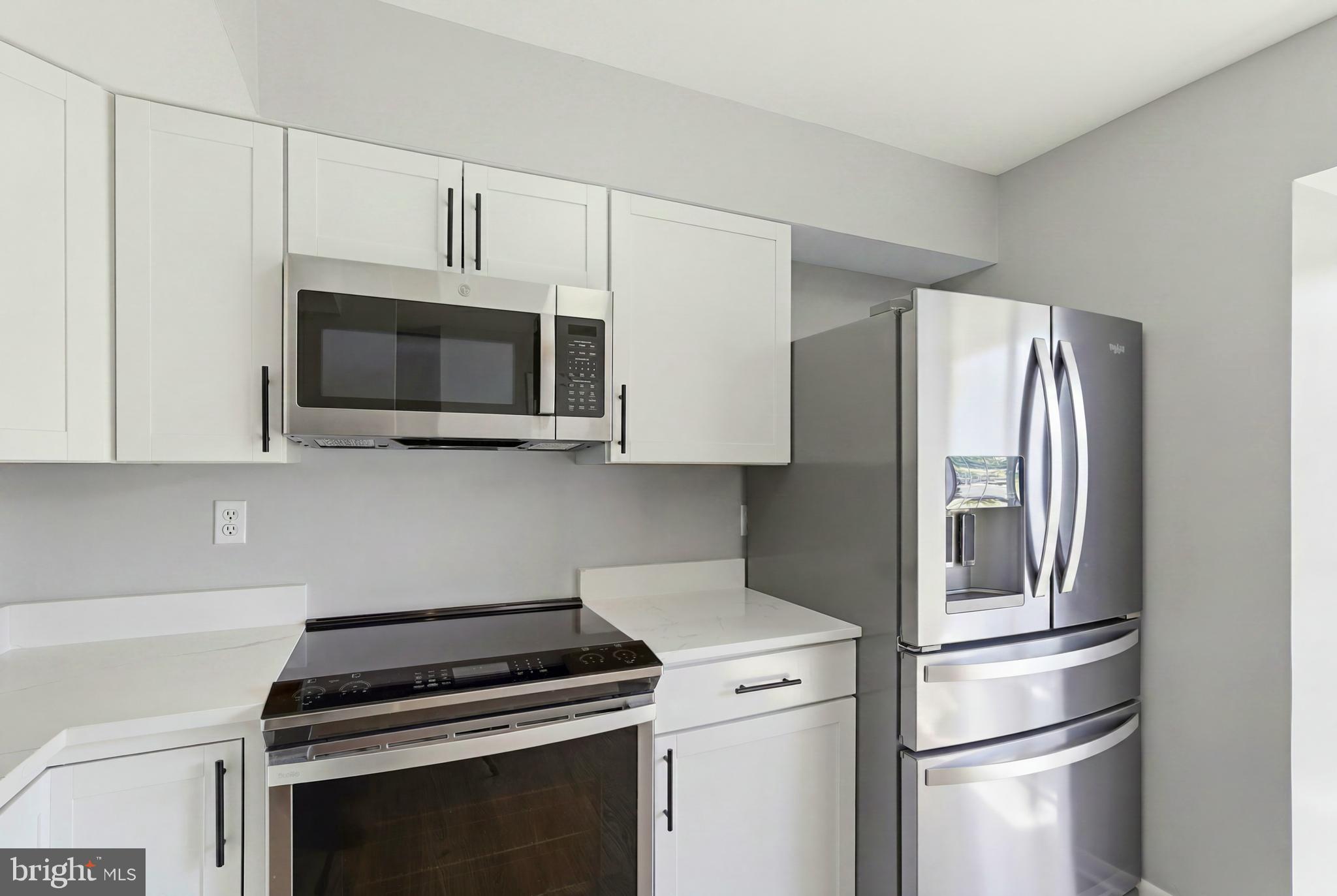 3682 Masthead Trail Triangle, VA 22172 - Photo 12 of 53 a kitchen with stainless steel appliances white cabinets and a stove top oven