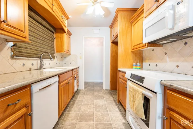 a large kitchen with stainless steel appliances granite countertop a stove and a refrigerator