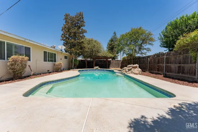 a view of a backyard with potted plants and large tree
