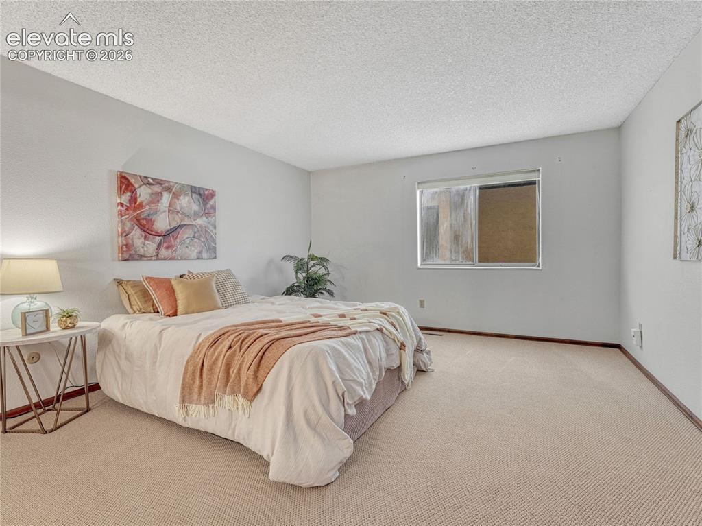 1146 Fontmore Road, Unit A Colorado Springs, CO 80904 - Photo 21 of 24 a bedroom with a bed and a painting on the wall