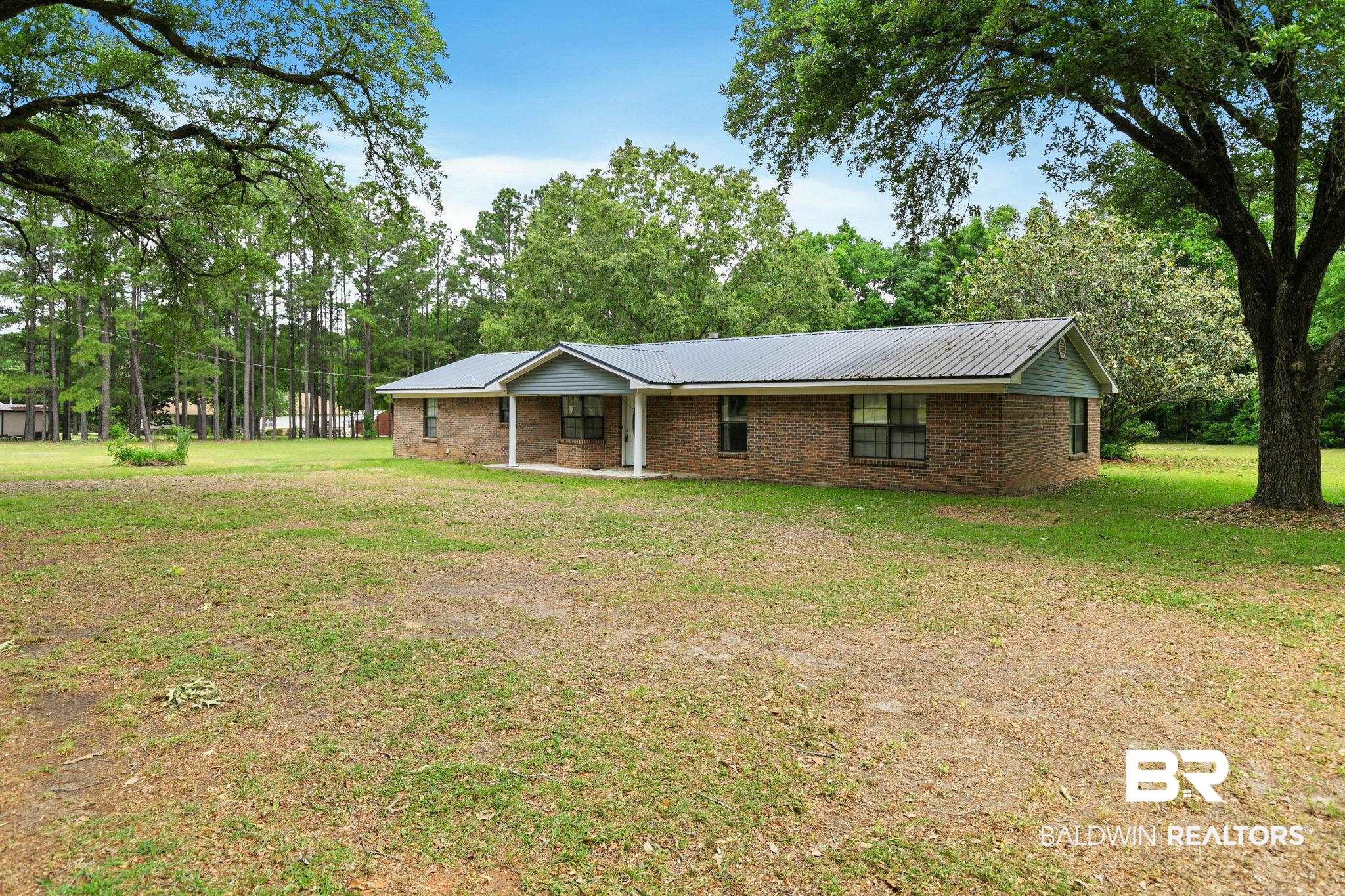 13653 Roberts Road Loxley, AL 36551 - Photo 3 of 33 Brick exterior home featuring a covered front porch, metal roof, and multiple windows