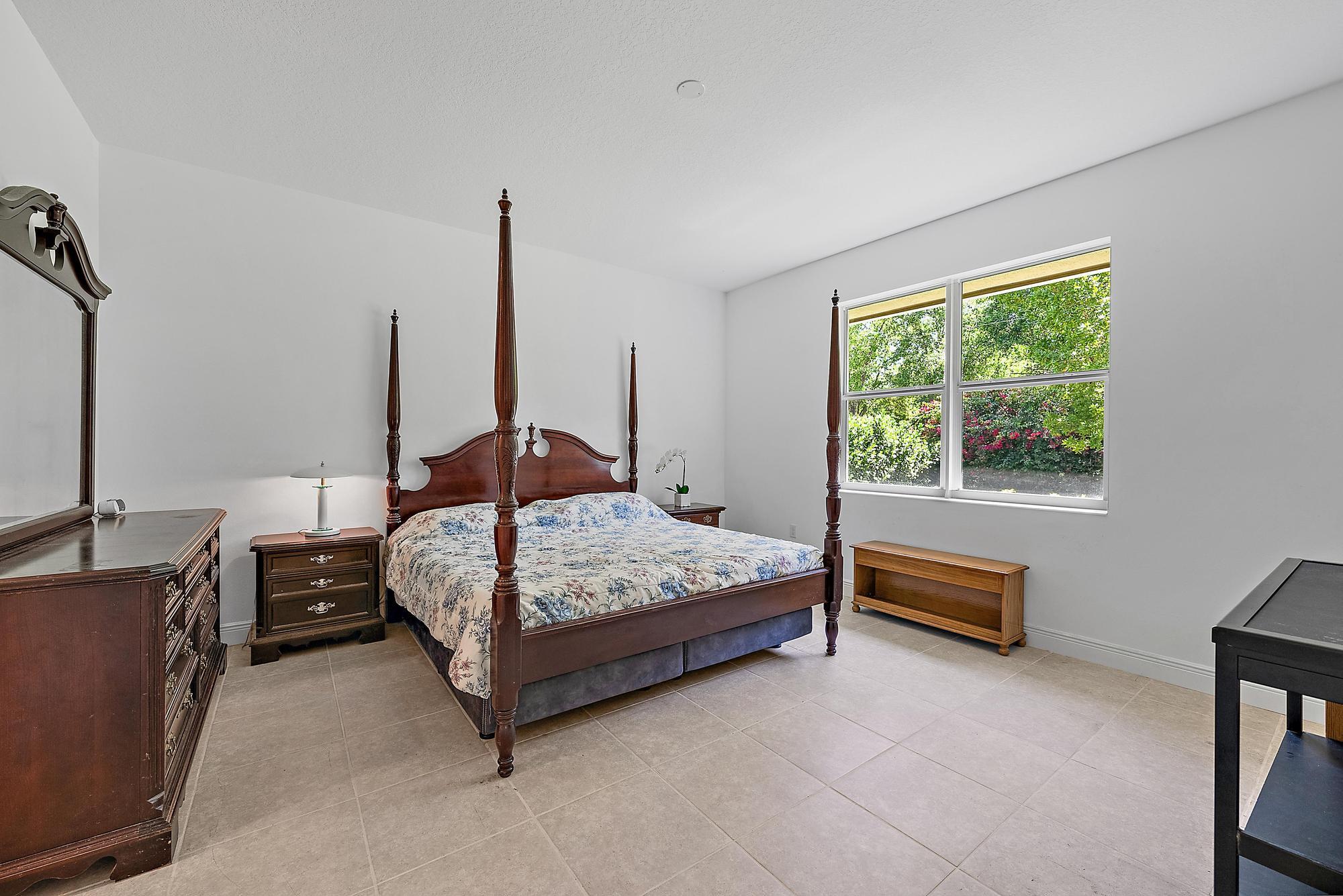 2664 Conifer Drive Fort Pierce, FL 34951 - Photo 12 of 30 a bedroom with a bed table and window