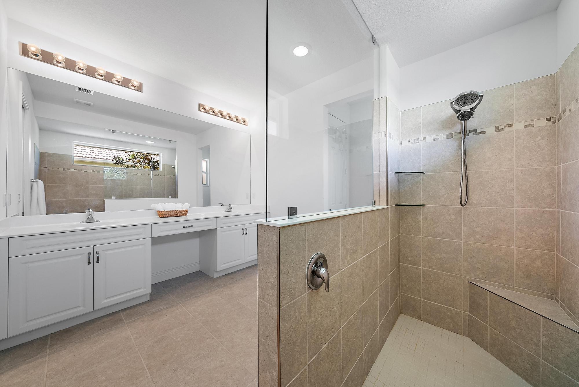 2664 Conifer Drive Fort Pierce, FL 34951 - Photo 14 of 30 a bathroom with a double vanity sink a toilet a mirror and shower