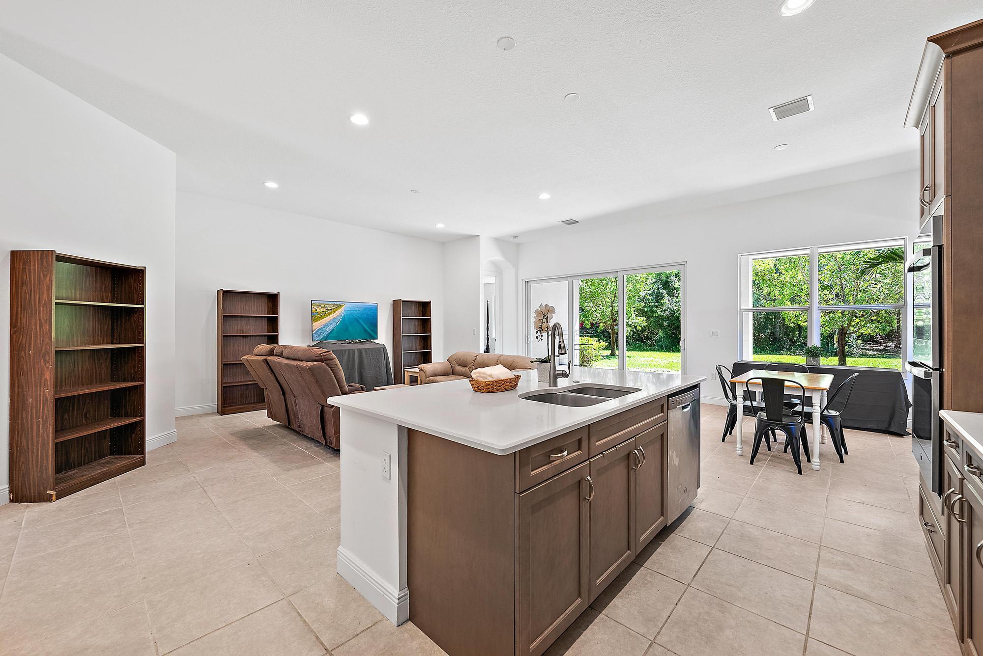 2664 Conifer Drive Fort Pierce, FL 34951 - Photo 7 of 30 a kitchen with a stove a refrigerator and a dining table