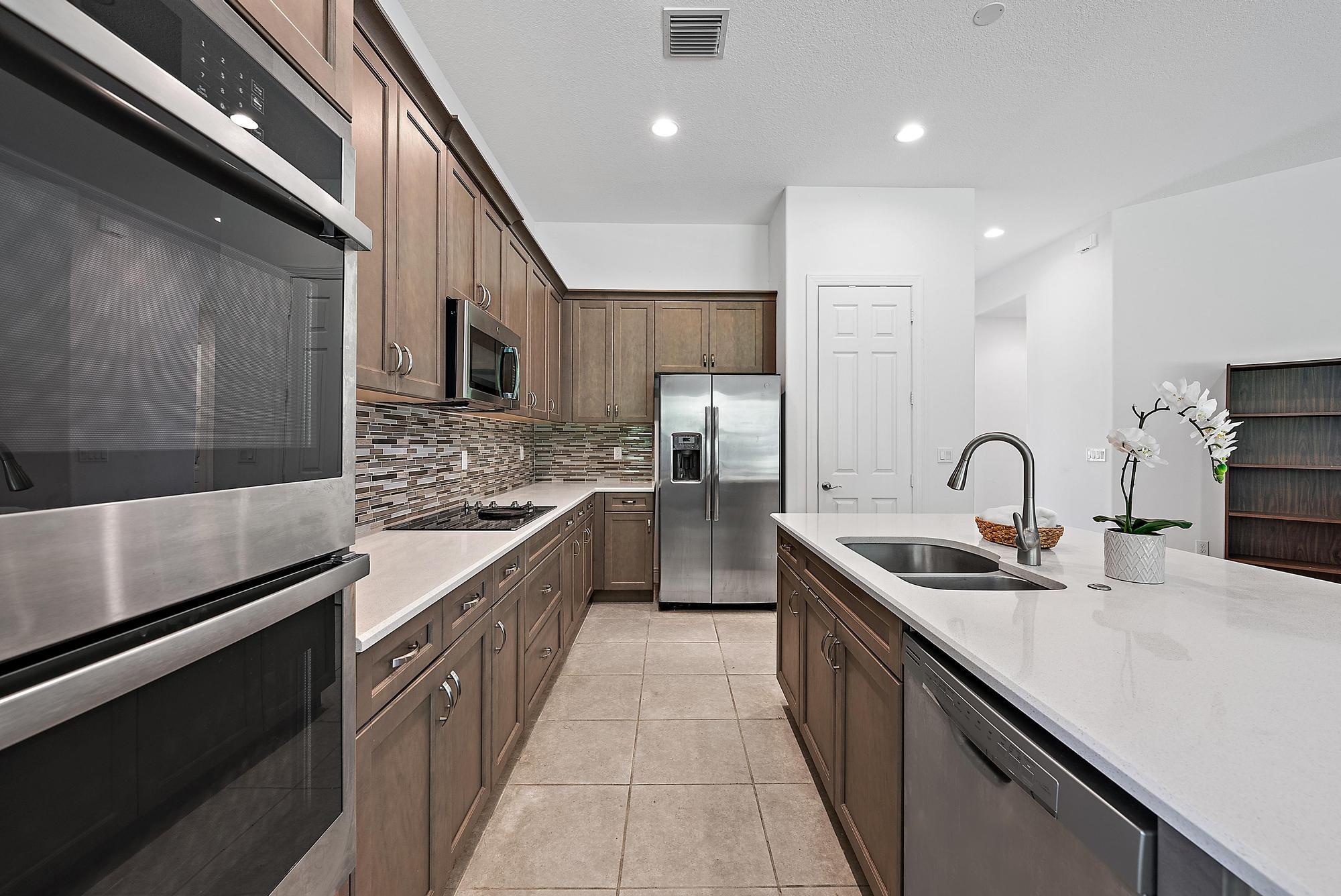 2664 Conifer Drive Fort Pierce, FL 34951 - Photo 8 of 30 a kitchen with stainless steel appliances granite countertop a sink and a stove