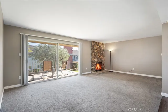 an empty room with floor to ceiling window and an outdoor view