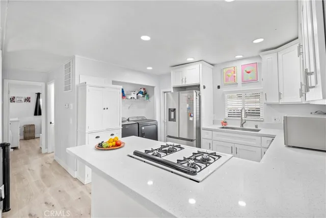 a kitchen with stainless steel appliances granite countertop a sink stove and refrigerator