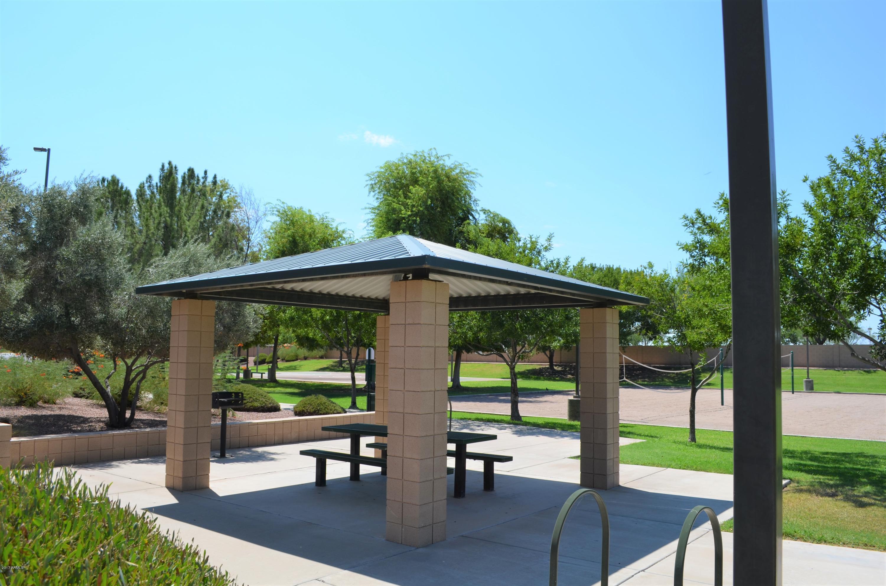 1742 East Del Rio Street Gilbert, AZ 85295 - Photo 26 of 28 a view of a patio with table and chairs under an umbrella with a large tree