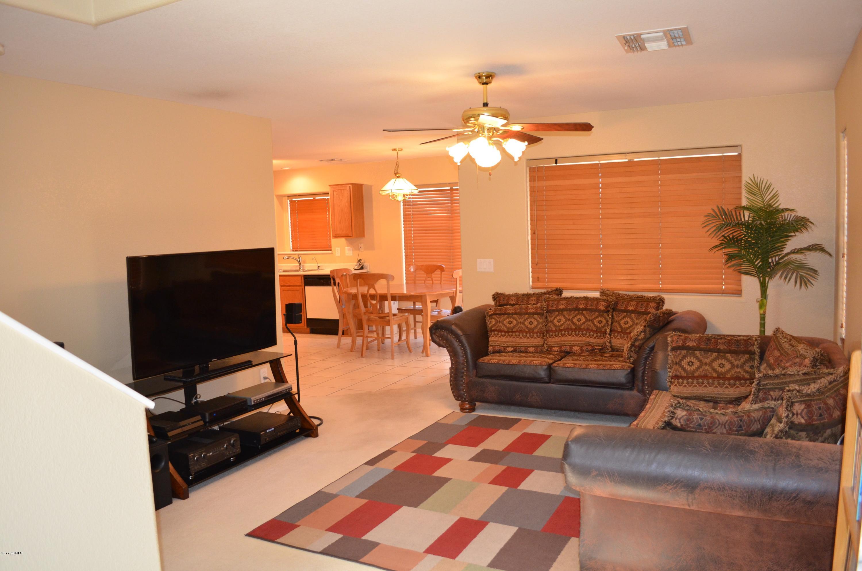 1742 East Del Rio Street Gilbert, AZ 85295 - Photo 5 of 28 a living room with furniture a flat screen tv and a floor to ceiling window