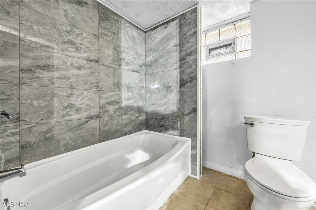 3403 Henderson Road Cleveland, OH 44112 - Photo 27 of 33 Bathroom with tile patterned flooring, toilet, and tiled shower / bath