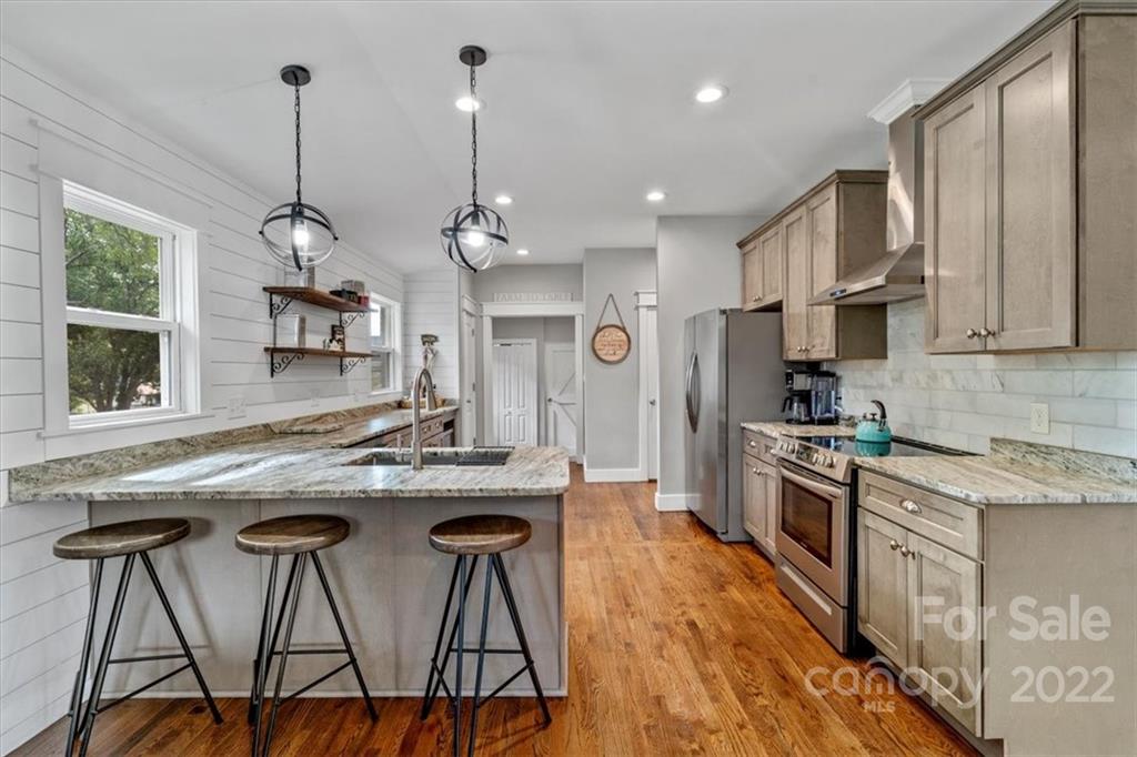 1631 Lawrence Road Clover, SC 29710 - Photo 13 of 48 a kitchen with stainless steel appliances granite countertop a kitchen island hardwood floor sink stove dining table and chairs