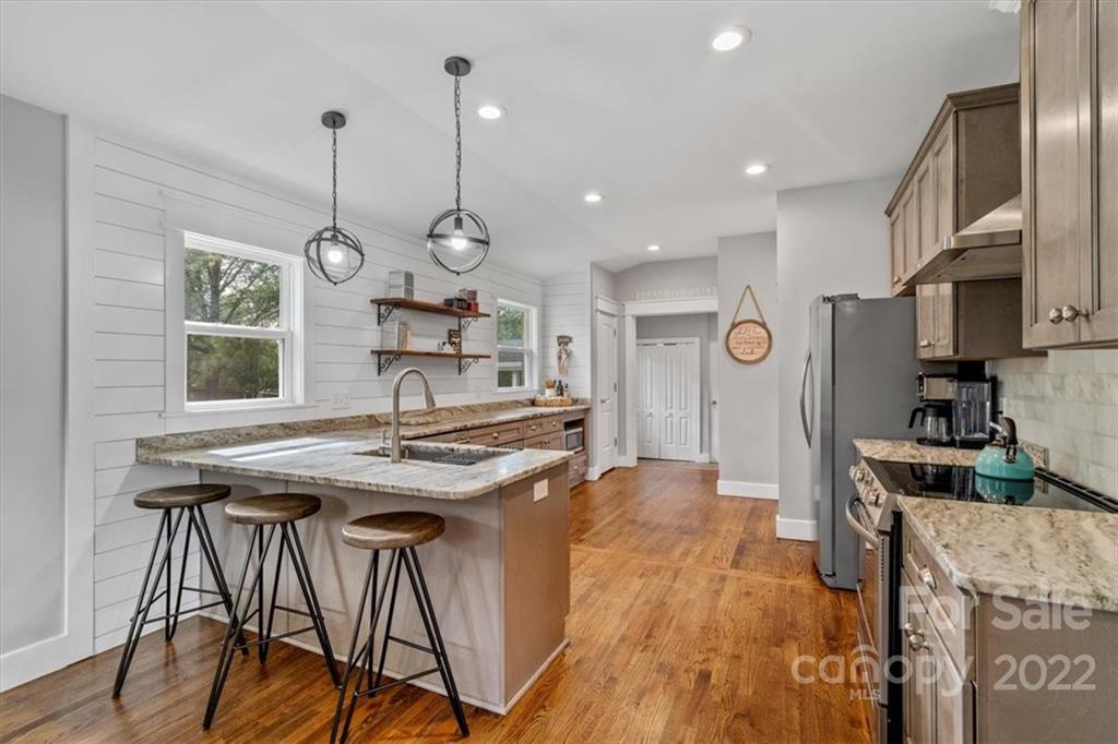 1631 Lawrence Road Clover, SC 29710 - Photo 14 of 48 a kitchen with stainless steel appliances granite countertop a stove a refrigerator a kitchen island a sink and a wooden cabinets