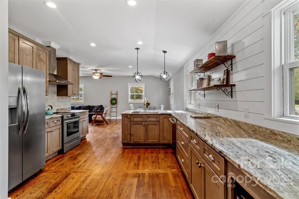 1631 Lawrence Road Clover, SC 29710 - Photo 15 of 48 a kitchen with stainless steel appliances granite countertop a kitchen island a stove a sink and a refrigerator