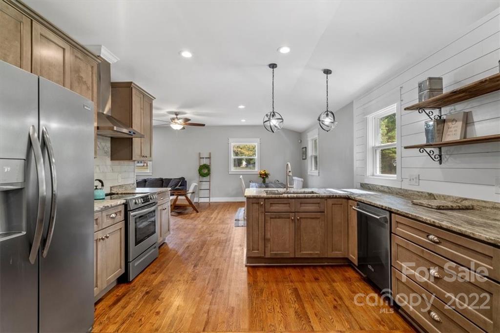 1631 Lawrence Road Clover, SC 29710 - Photo 19 of 48 a kitchen with stainless steel appliances granite countertop hardwood floor sink stove and refrigerator